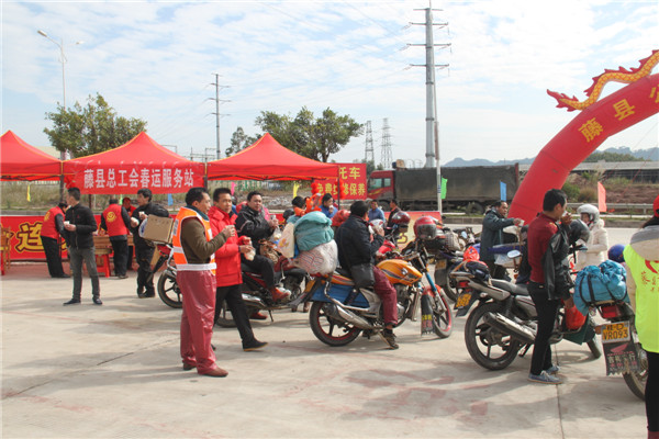 圖為藤縣總工會(huì)在省道304線藤縣陶瓷工業(yè)園區(qū)商業(yè)街小廣場(chǎng)設(shè)立藤縣總工會(huì)為農(nóng)民工平安返鄉(xiāng)“暖流行動(dòng)”服務(wù)站，積極為騎摩托車